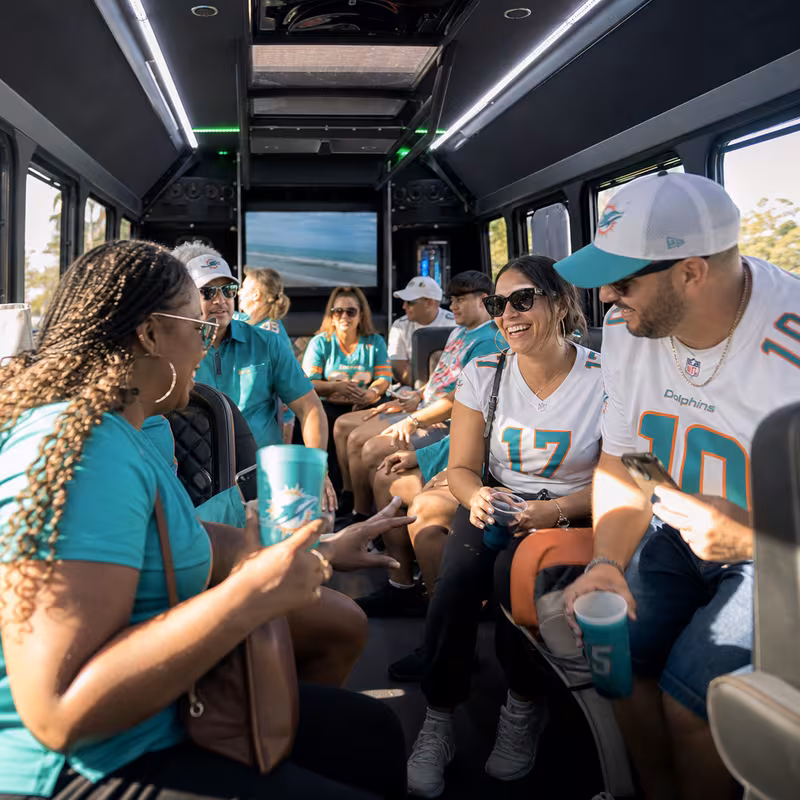 Group boarding a white charter bus for Sporting Event Transportation transportation in Fort Lauderdale